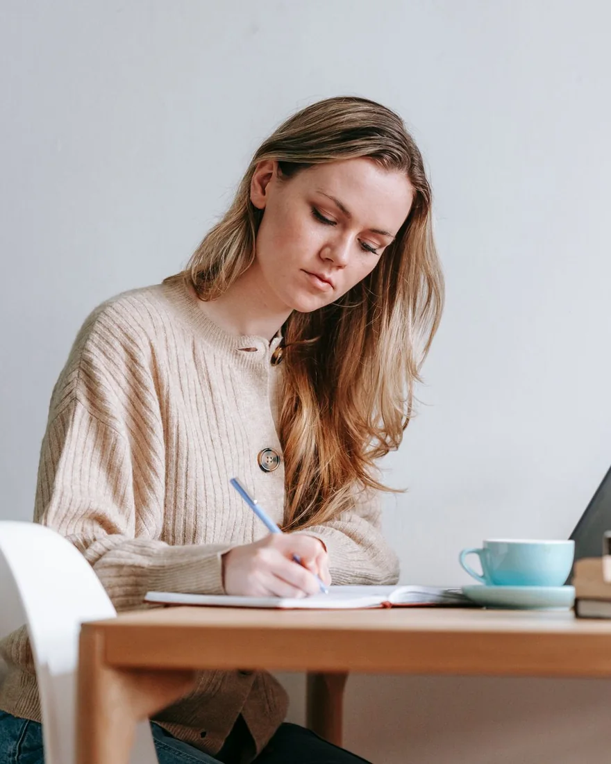 Someone writing notes at a desk